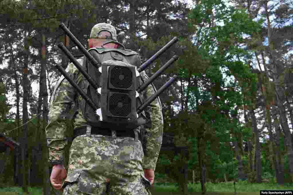 Украинский военный с «антидроновым рюкзаком» во время демонстрации устройства, создающего помехи беспилотникам. Львовская область, май 2024 года