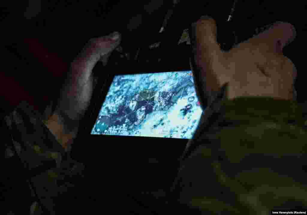 Украинский военный смотрит на монитор, на котором видно тело российского солдата, убитого дроном-камикадзе. Россия и Украина владеют тысячами дронов, которые направляют на поля сражений