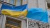 «Два флага – одна страна». Украинский государственный и крымскотатарский национальный флаги на флагштоках перед зданием МИД Украины в Киеве