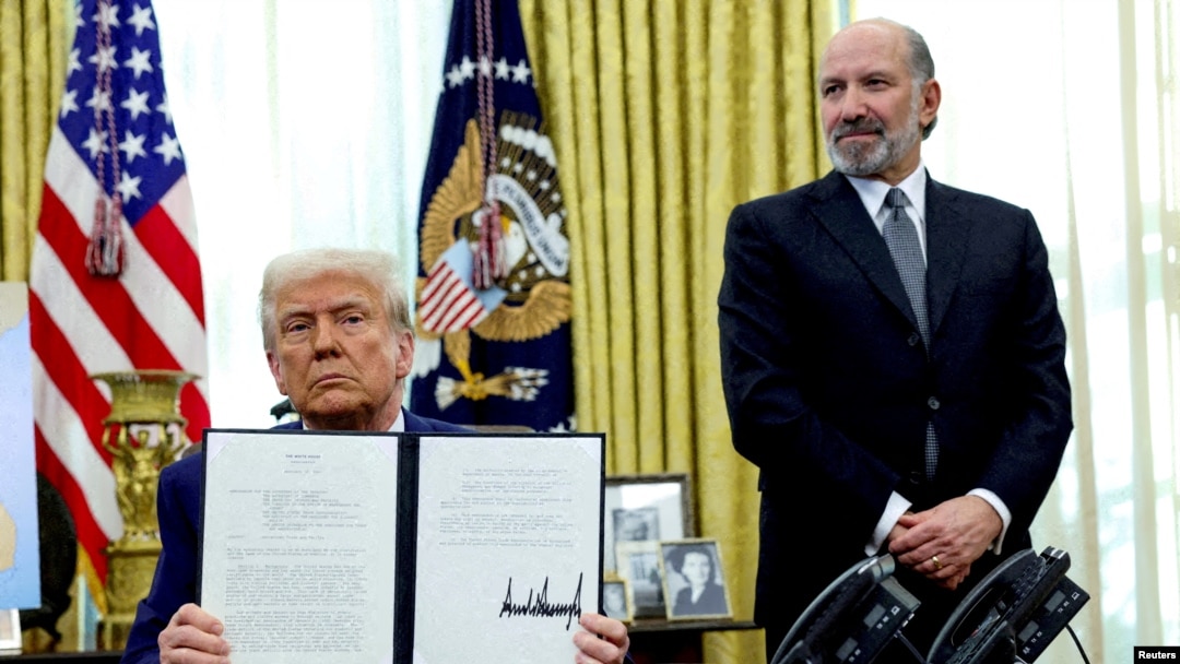 Američki predsednik Donald Tramp pokazuje potpisanu izvršnu naredbu o povećanju carina u prisustvu ministra trgovine Hauarda Lutnika u Vašingtonu, SAD, februar 2025.