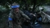 Український військовослужбовець 60-ї окремої механізованої бригади готує снаряди для важкого бойового безпілотника перед польотом над позиціями російських військ e Донецькій області, Україна, 20 травня 2024 року