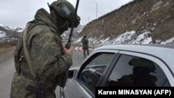 Nagorno-Karabakh - A Russian soldier of the peacekeeping force controls a vehicle at a checkpoint on a road outside Stepanakert on November 26, 2020.