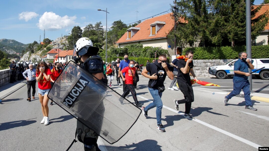 Demonstranti bježe dok policajac čuva red na protestu protiv ustoličenja mitropolita SPC Joanikija na Cetinju, Crna Gora, 4. septembra 2021.