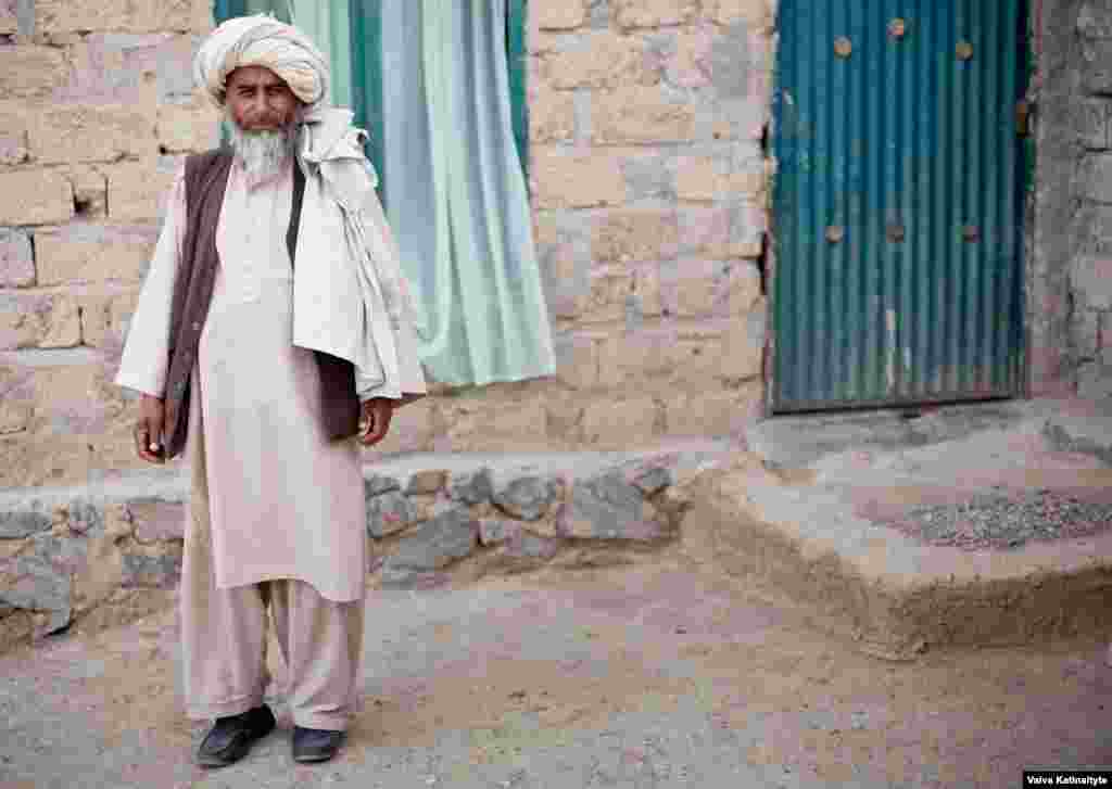 Haji Khanzada, a local elder, provides food and water for the returnees. 