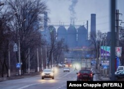 Чоловік перебігає дорогу перед маріупольським металургійним комбінатом імені Ілліча у похмурий пополудень, 4 лютого 2022 року