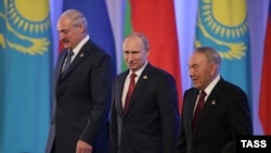Президент Беларуси Александр Лукашенко (слева), президент России Владимир Путин (в центре) и президент Казахстана Нурсултан Назарбаев после церемонии подписания соглашения о создании Евразийского экономического союза. Астана, 29 мая 2014 года.
