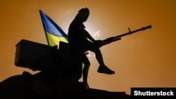 Ukraine – Ukrainian flag, man and machine gun.